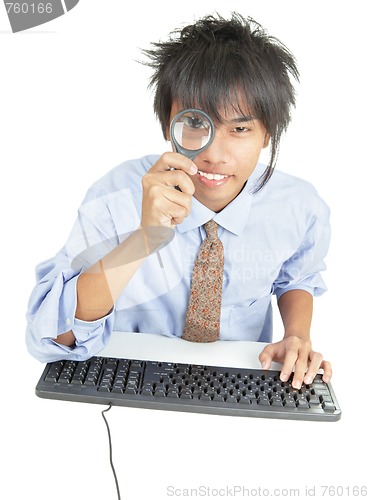Image of Young Asian businessman peering thru magnifier