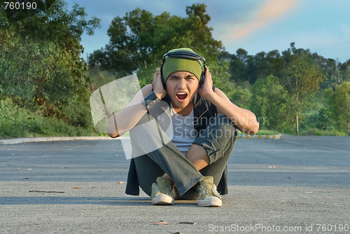 Image of Suburban rapper covering ears