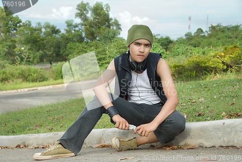 Image of Suburban rapper sitting on street