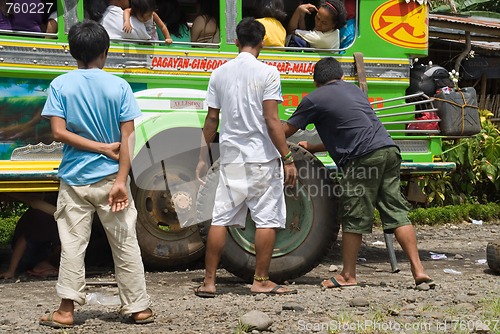 Image of Filipino jeepney tire change