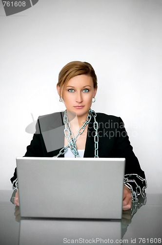 Image of Beautiful young businesswoman chained to laptop