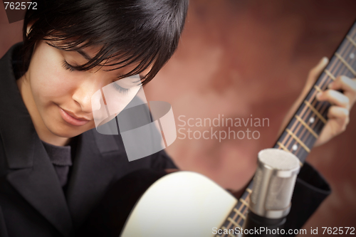 Image of Attractive Ethnic Girl Plays Guitar