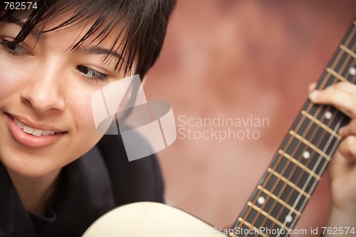 Image of Attractive Ethnic Girl Plays Guitar