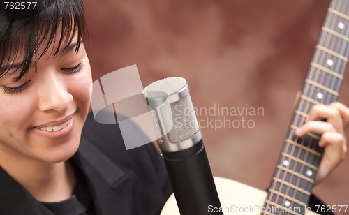 Image of Attractive Ethnic Girl Plays Guitar