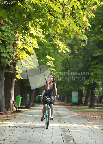 Image of Woman on the phone riding bicycle