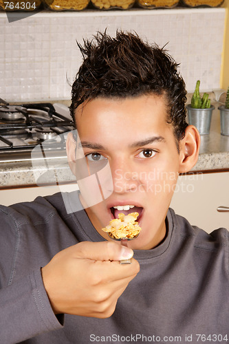 Image of Young man eating cornflakes