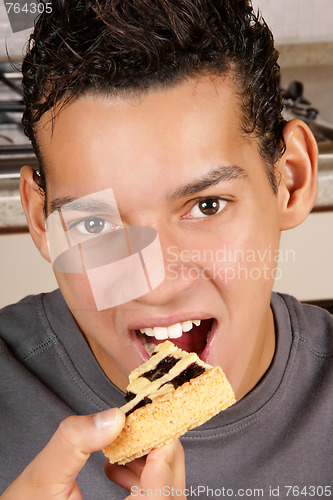 Image of Young man eating fruit tart