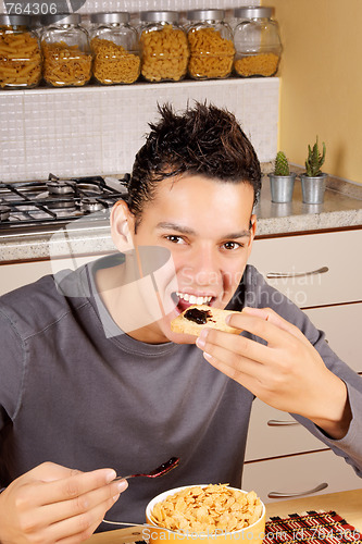 Image of Young man having breakfast at home