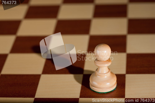 Image of Chess piece - a white pawn on a chessboard.