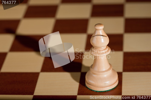 Image of Chess piece - a white bishop on a chessboard.