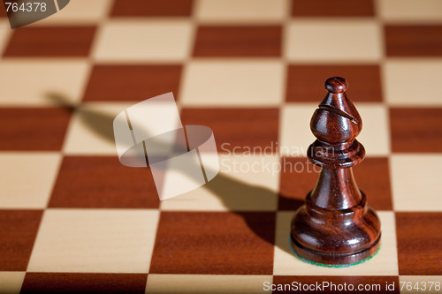 Image of Chess piece - a black bishop on a chessboard.