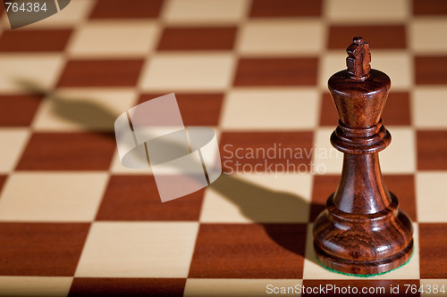 Image of Chess piece - a black king on a chessboard.
