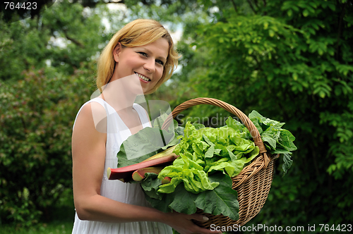 Image of Young woman holding basket with vegetable