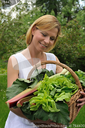 Image of Young woman holding basket with vegetable