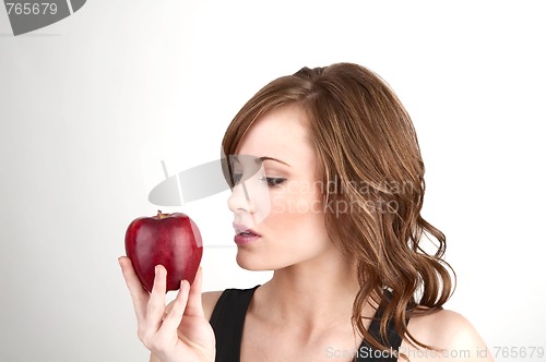 Image of Beautiful girl examining an apple