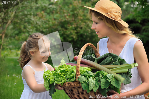 Image of Young woman and daughter with fresh vegetable