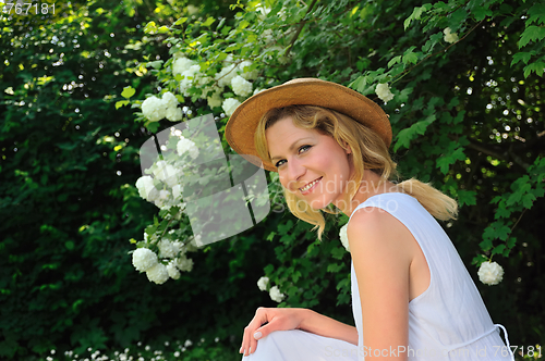 Image of Young woman resting in garden