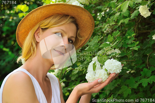 Image of Young woman gardening - taking care of snowball