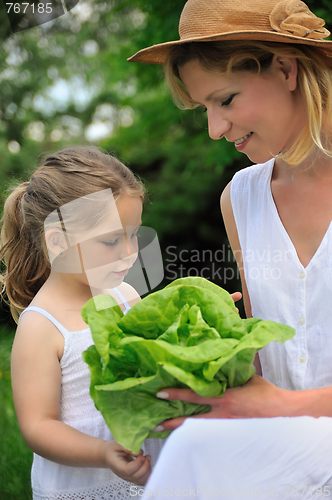 Image of Young mother and daughter with lettuce