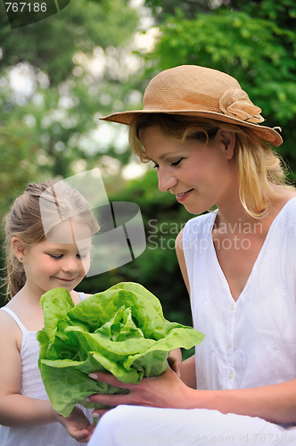 Image of Young mother and daughter with lettuce