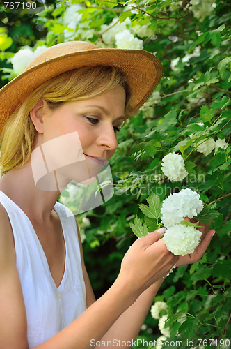 Image of Young woman gardening - taking care of snowball