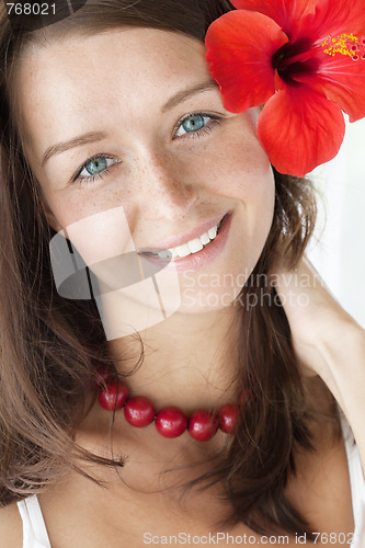 Image of smiling brunette with red flower