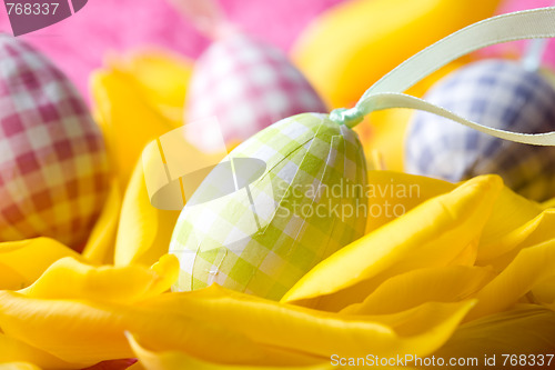 Image of Easter eggs on yellow tulip petals