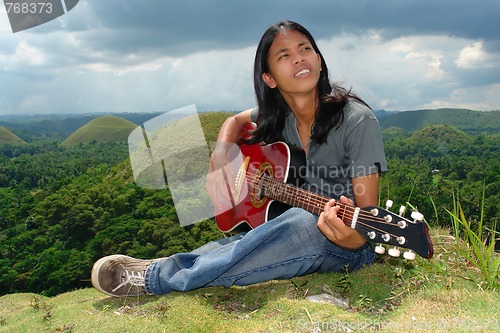 Image of Pensive Asian hippie w guitar