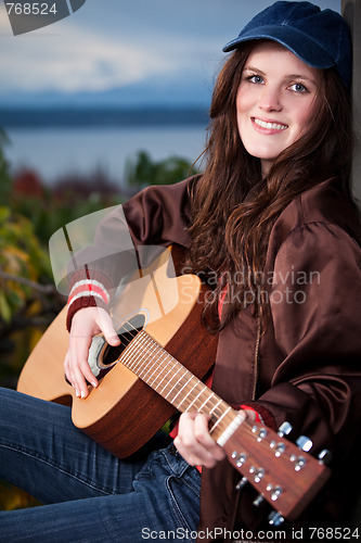 Image of Beautiful teenager playing guitar