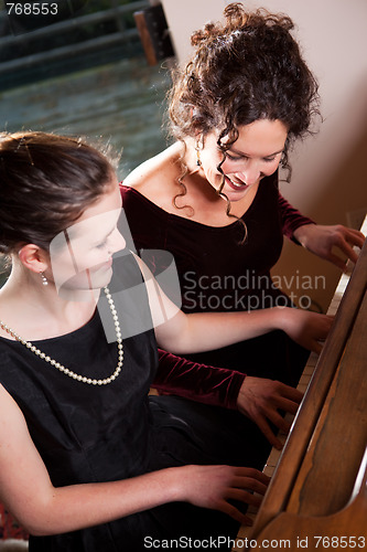 Image of Mother and daughter playing piano