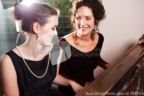 Image of Mother and daughter playing piano