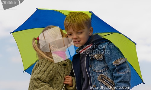 Image of Little boy and girl with umbrella