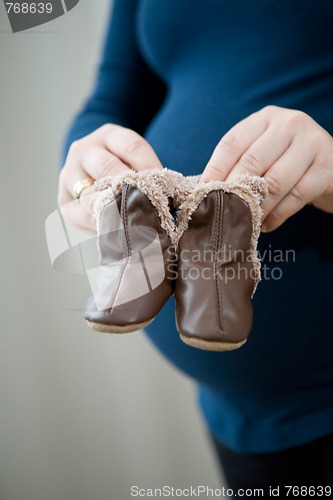 Image of Pregnant mother holding baby booties