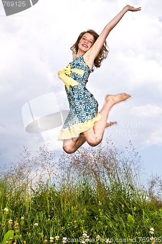 Image of Young girl jumping in meadow