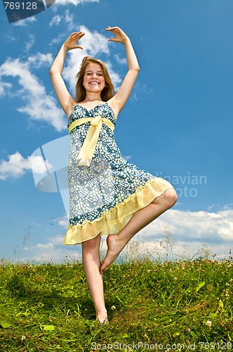 Image of Young girl dancing in meadow