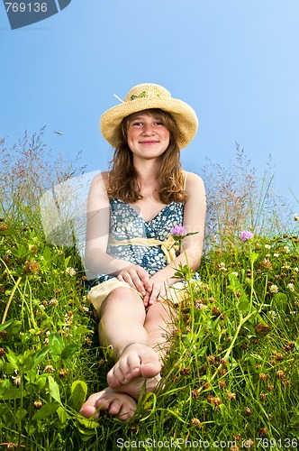 Image of Young girl sitting in meadow