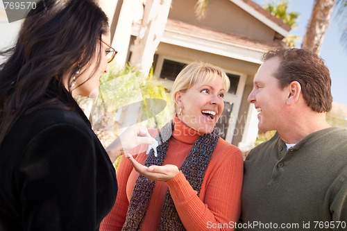 Image of Hispanic Female Real Estate Agent Handing Keys to Excited Couple