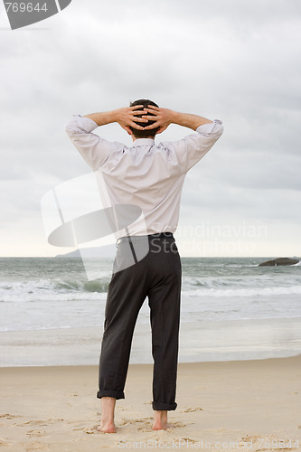 Image of Businessman relaxing on beach