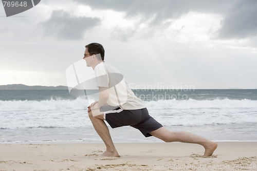 Image of Man doing fitness exercises on a beach