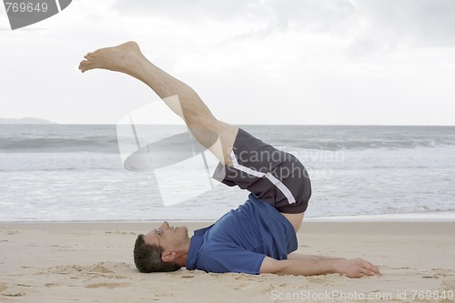 Image of Man doing fitness exercises on a beach