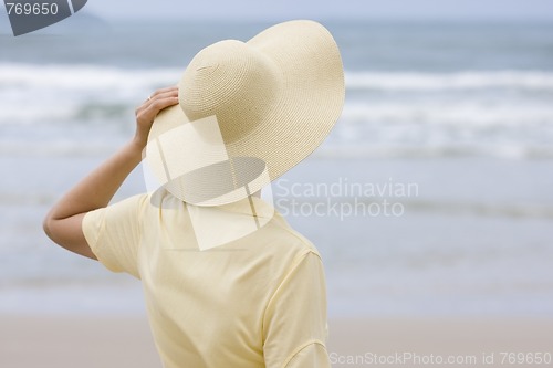 Image of Woman with hat looking at the sea