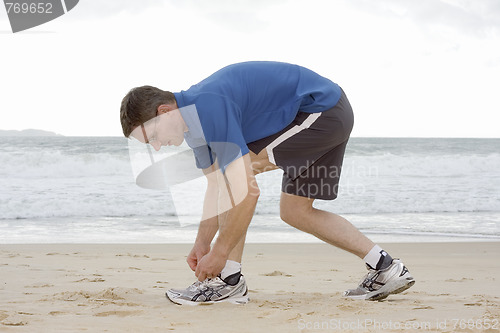 Image of Runner tying his shoes