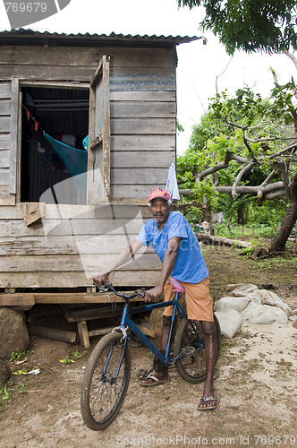 Image of editorial native man with bicycle in front of typical house corn