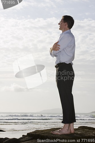 Image of Businessman on a rock by the sea