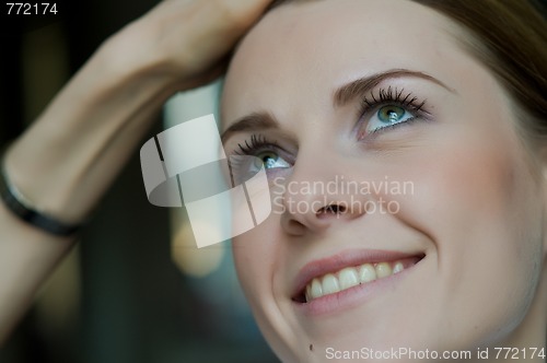 Image of Woman applying makeup