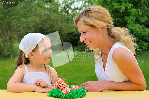 Image of Young mother and daughter having Easter time