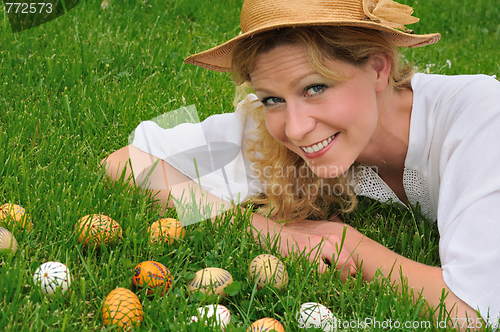 Image of Young woman and easter eggs on the grass - Easter time