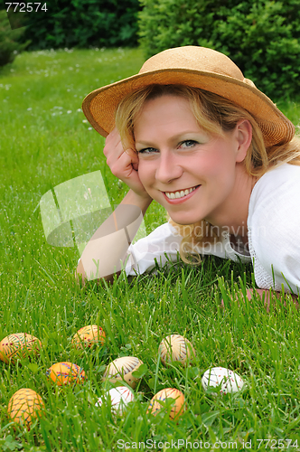 Image of Young woman and easter eggs on the grass - Easter time