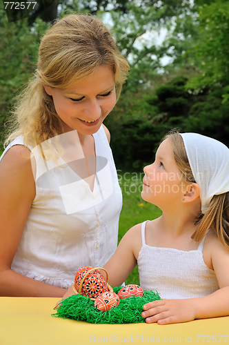 Image of Young mother and daughter having Easter time