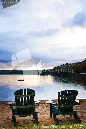 Image of Wooden chairs at sunset on beach